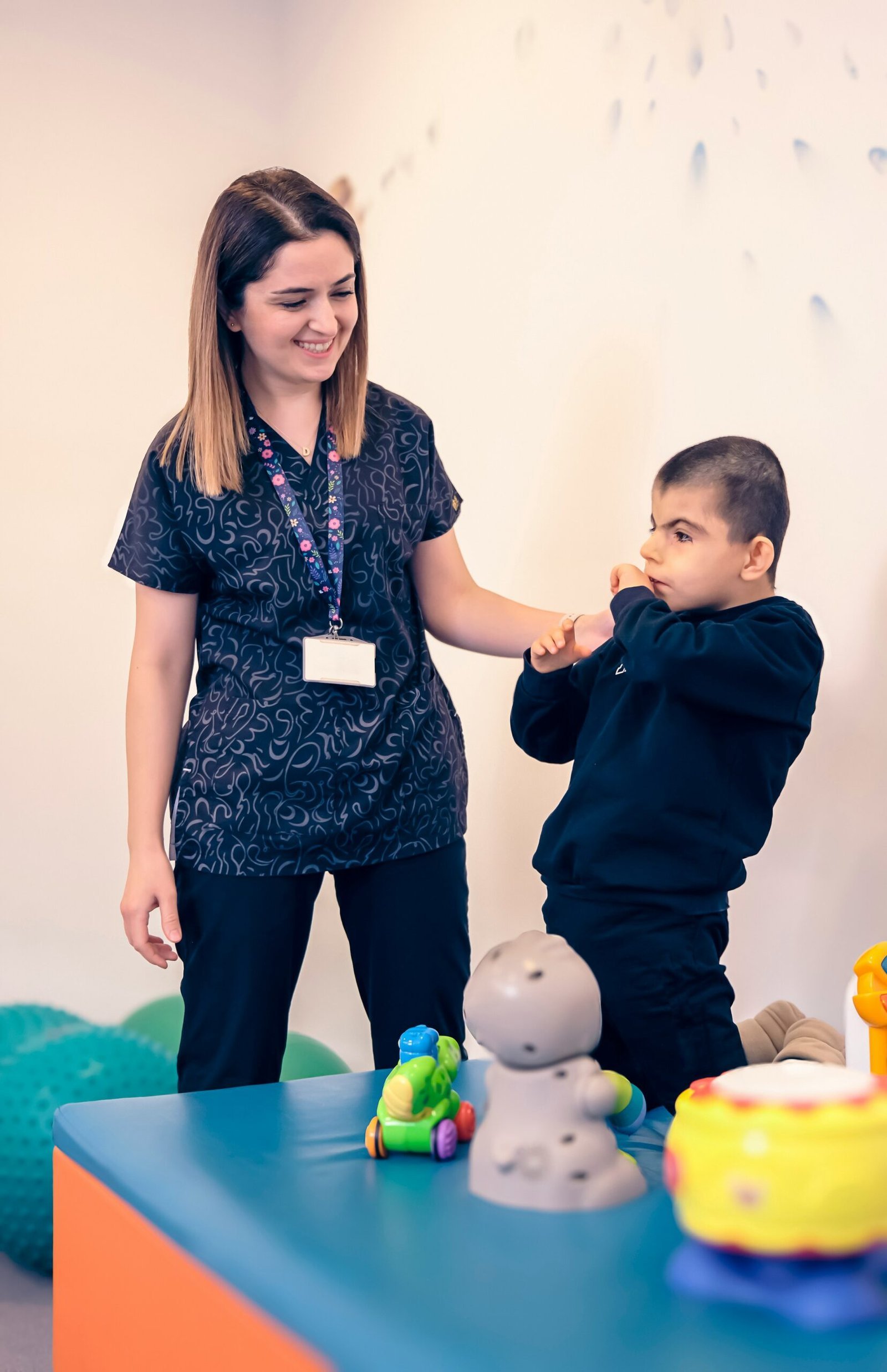 a woman standing next to a boy in a room